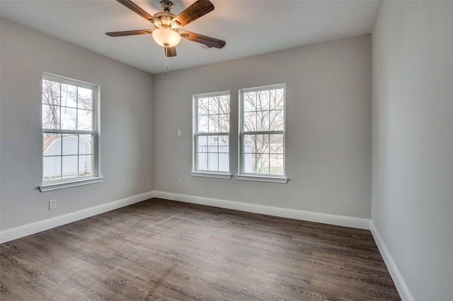 empty room featuring dark wood-type flooring, baseboards, and a ceiling fan