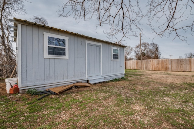 view of outbuilding featuring fence and an outbuilding