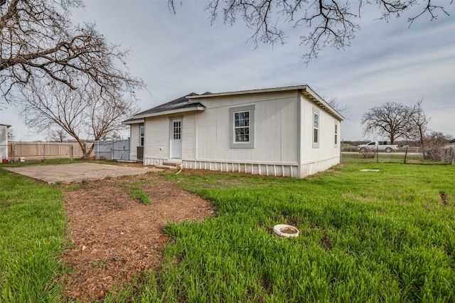 view of front of house featuring a front yard, fence, and a patio