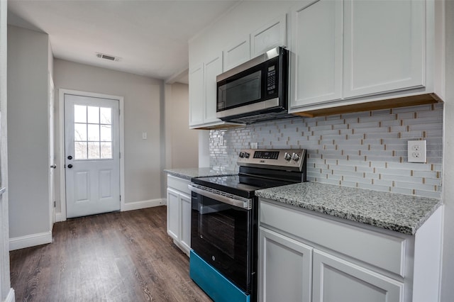 kitchen featuring light stone counters, white cabinetry, appliances with stainless steel finishes, decorative backsplash, and dark wood-style floors