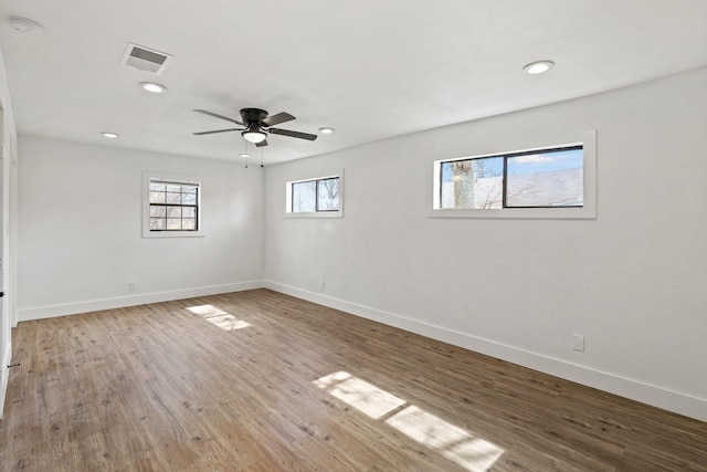 spare room with baseboards, visible vents, wood finished floors, and recessed lighting