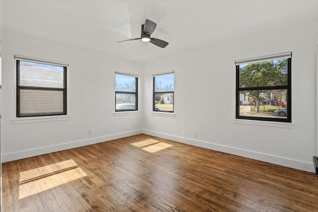 empty room with a ceiling fan, wood-type flooring, and baseboards