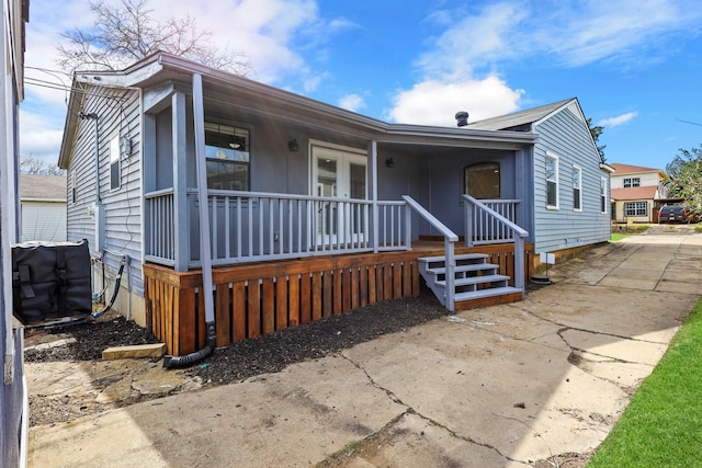 view of front of house with covered porch and french doors