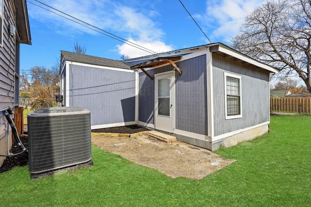 view of outbuilding featuring fence and cooling unit