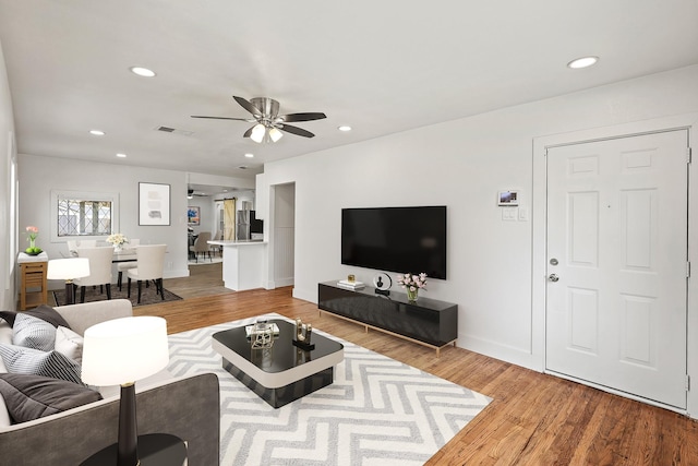 living area featuring recessed lighting, visible vents, and wood finished floors