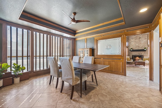 dining area featuring a textured ceiling, a tray ceiling, and plenty of natural light