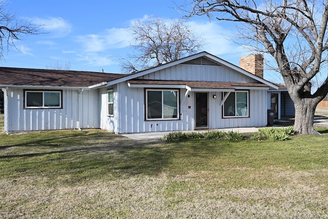 view of front facade with a chimney and a front lawn