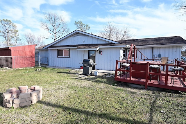 back of house with a deck, a yard, a fire pit, and fence