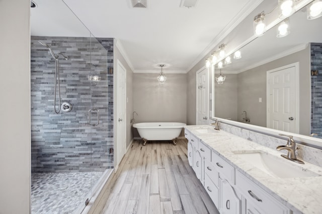 bathroom featuring ornamental molding, a sink, and a shower stall