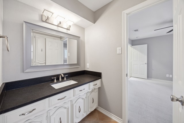 bathroom with tile patterned flooring, vanity, baseboards, visible vents, and a ceiling fan