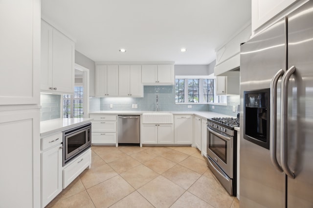 kitchen featuring backsplash, stainless steel appliances, light countertops, and light tile patterned flooring