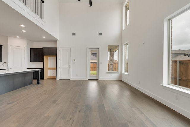 1517 Kinglet Pl, Celina, TX 75009 - unfurnished living room featuring a towering ceiling, baseboards, light wood finished floors, recessed lighting, and ceiling fan