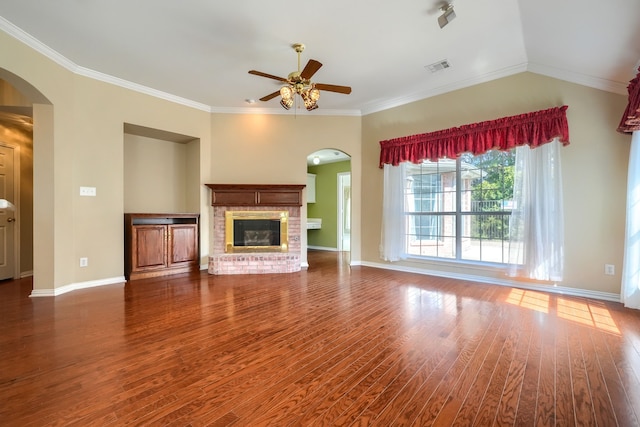 unfurnished living room with dark wood-style floors, arched walkways, a fireplace, and baseboards