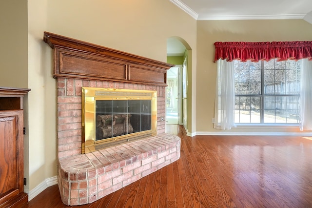 unfurnished living room featuring arched walkways, ornamental molding, a fireplace, and wood finished floors