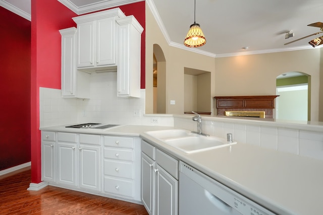 kitchen with white cabinets, dishwasher, ornamental molding, light countertops, and a sink