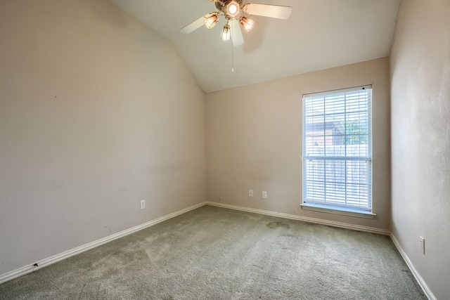 empty room with lofted ceiling, carpet floors, ceiling fan, and baseboards