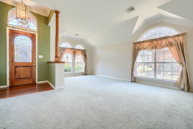 entrance foyer with decorative columns, visible vents, baseboards, carpet, and vaulted ceiling