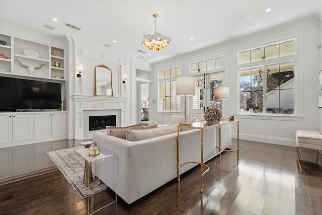 living area with built in shelves, visible vents, a fireplace, and dark wood-style floors