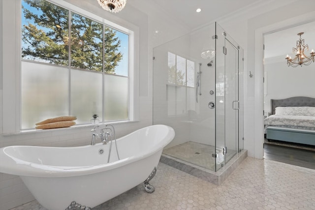 bathroom featuring tile walls, a soaking tub, ensuite bathroom, an inviting chandelier, and a stall shower