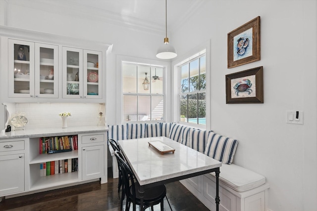 dining area with breakfast area, ornamental molding, and dark wood-style floors