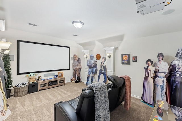 carpeted cinema room featuring decorative columns, visible vents, and baseboards