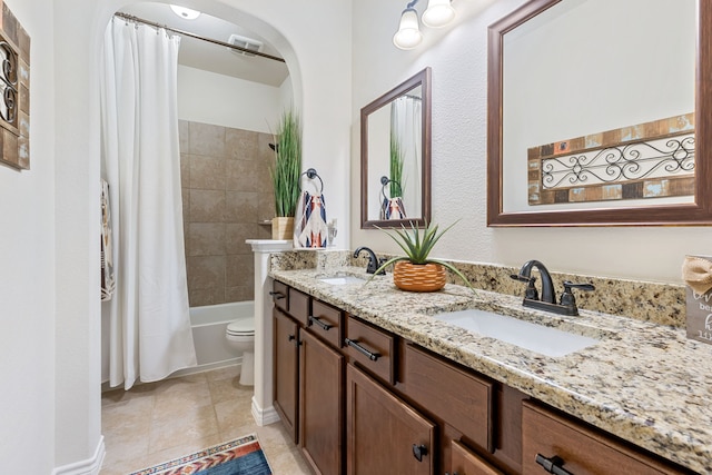 bathroom with tile patterned flooring, a sink, toilet, and double vanity