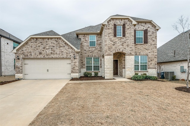 french country style house with a garage, central AC, brick siding, concrete driveway, and roof with shingles