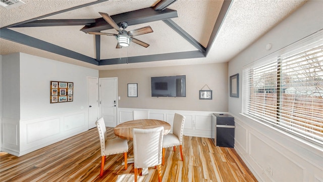 dining space with a textured ceiling, ceiling fan, light wood finished floors, and lofted ceiling