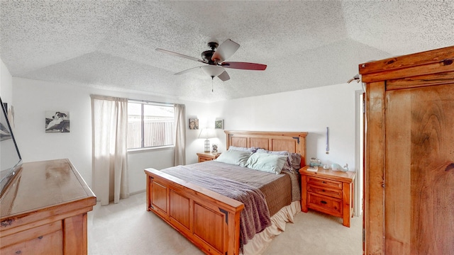 bedroom featuring a ceiling fan, light carpet, and a textured ceiling