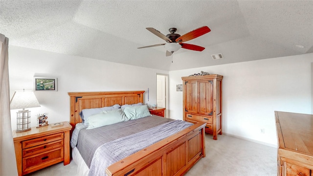 bedroom featuring light colored carpet, visible vents, and a textured ceiling