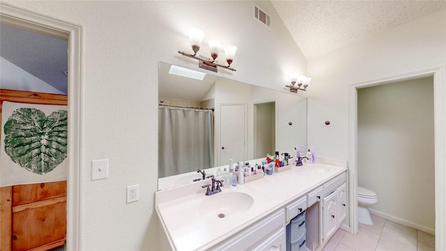 full bath with lofted ceiling with skylight, visible vents, a sink, and a textured ceiling