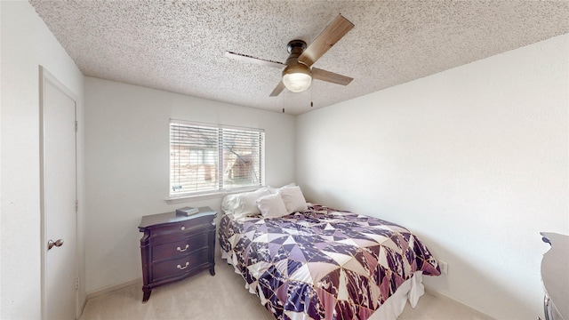 bedroom featuring light colored carpet, ceiling fan, and a textured ceiling