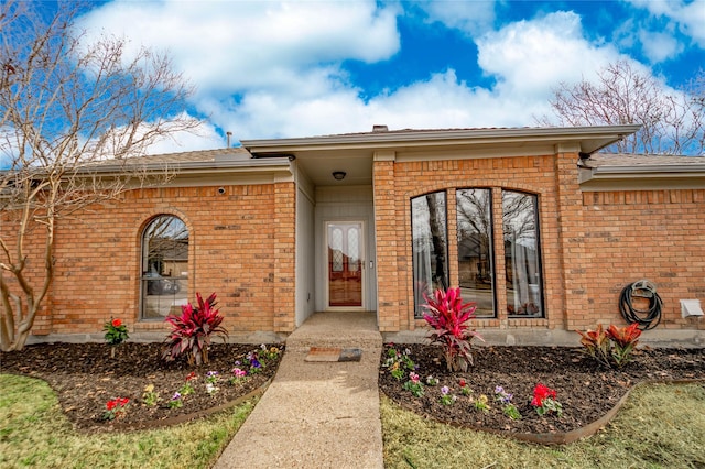 doorway to property featuring brick siding