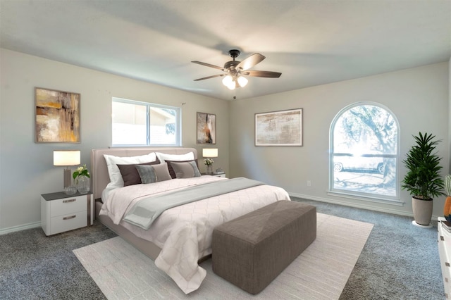 carpeted bedroom with ceiling fan and baseboards