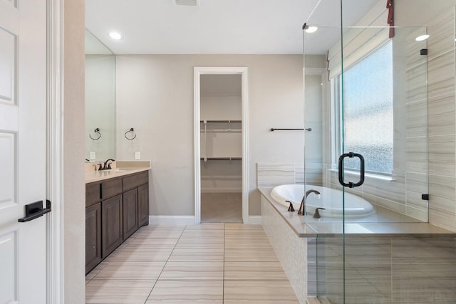 bathroom with a stall shower, tile patterned flooring, vanity, and a bath