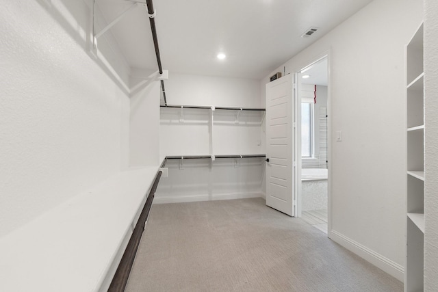 spacious closet featuring light colored carpet and visible vents