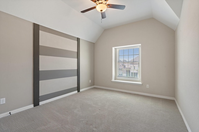 unfurnished room featuring light carpet, vaulted ceiling, baseboards, and ceiling fan