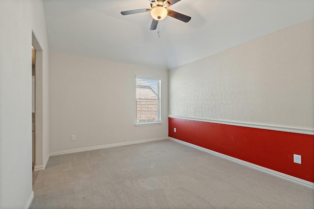 spare room with baseboards, ceiling fan, and light colored carpet