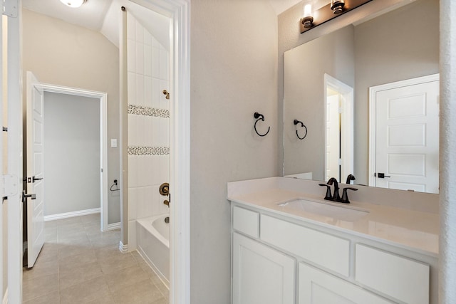 bathroom with washtub / shower combination, tile patterned flooring, vanity, and baseboards