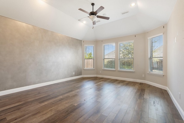 spare room featuring dark wood-type flooring, plenty of natural light, visible vents, and baseboards