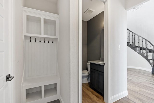 mudroom featuring baseboards, visible vents, and light wood finished floors