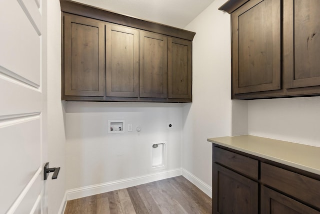 clothes washing area featuring hookup for a washing machine, hookup for a gas dryer, wood finished floors, cabinet space, and electric dryer hookup