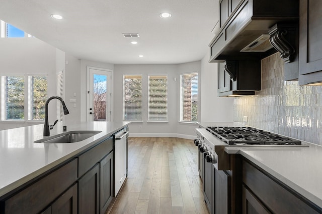 kitchen with light countertops, appliances with stainless steel finishes, a sink, and visible vents