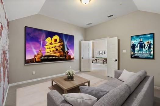 home theater featuring visible vents, baseboards, and vaulted ceiling