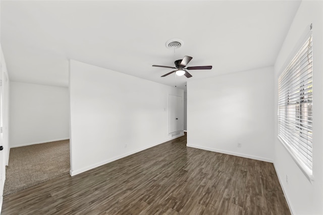 unfurnished room with dark wood-type flooring, visible vents, and baseboards