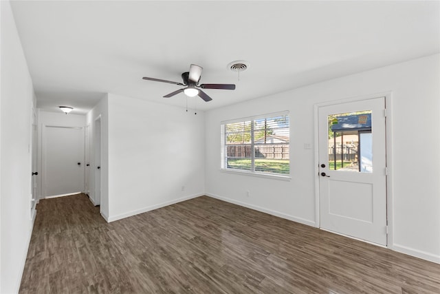 interior space with baseboards, visible vents, and dark wood-type flooring