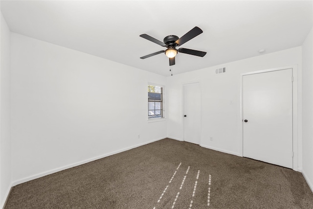 unfurnished bedroom featuring ceiling fan, baseboards, visible vents, and dark colored carpet