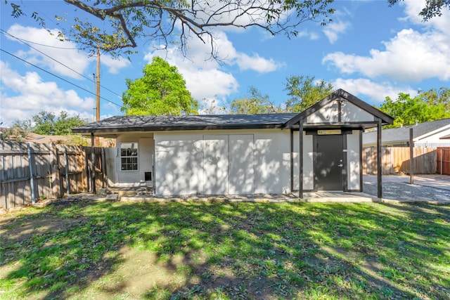 back of property featuring a fenced backyard and a lawn