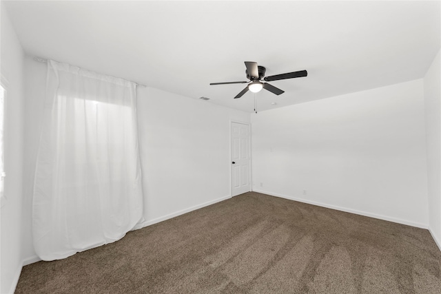 empty room featuring carpet floors, visible vents, baseboards, and a ceiling fan