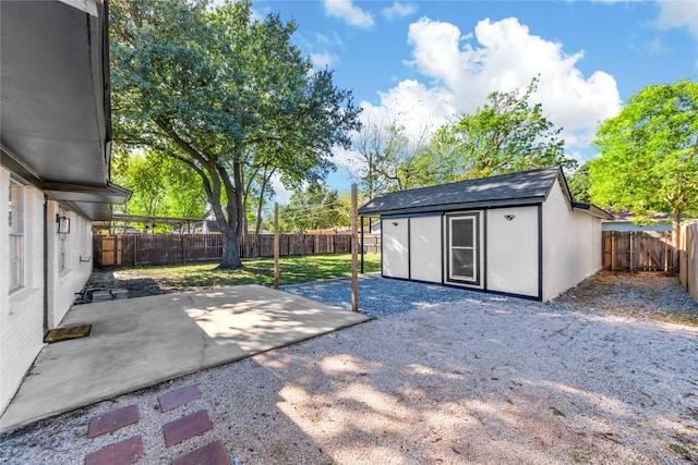 view of yard featuring a patio, an outdoor structure, and a fenced backyard